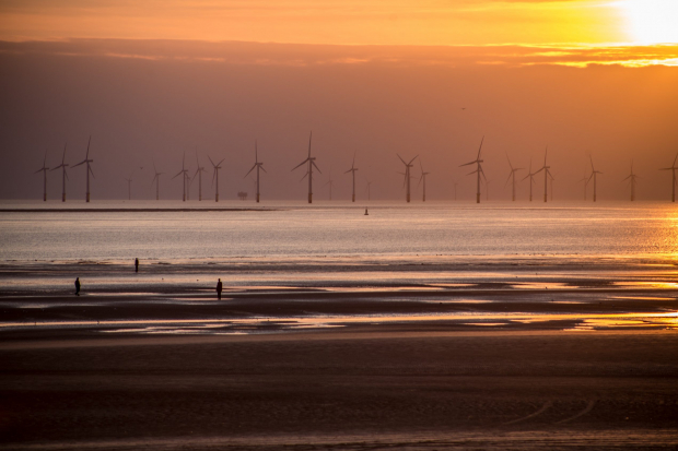 Beach at sunset with wind turbines in distance